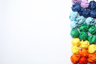 Colorful paper balls on white background, top view