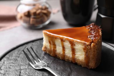 Piece of delicious cake with caramel served on plate, closeup