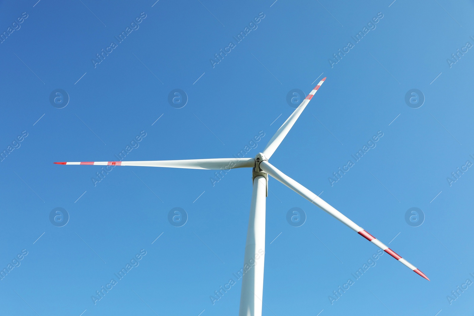 Photo of Modern wind turbine against blue sky, low angle view. Alternative energy source