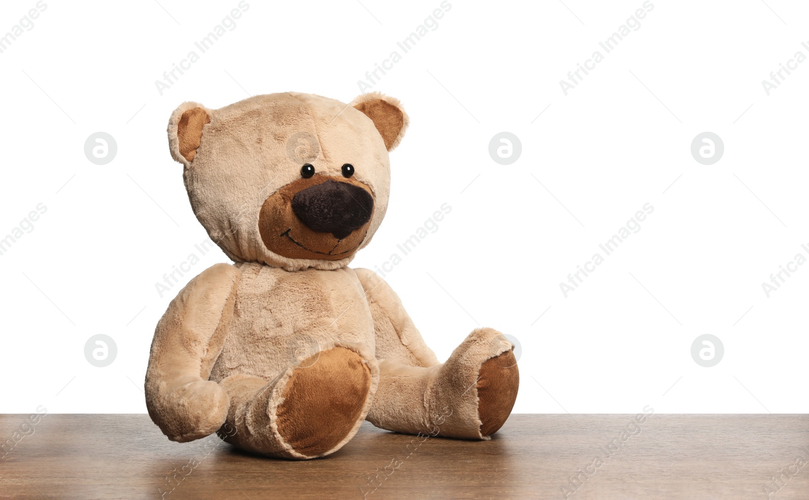 Photo of Cute teddy bear on wooden table against white background