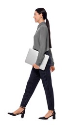 Photo of Young businesswoman with laptop walking on white background