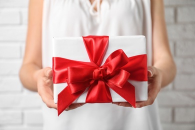 Woman holding beautiful gift box, closeup