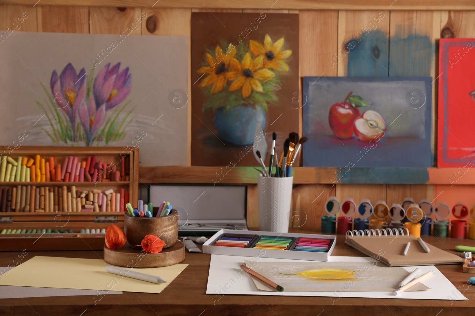 Photo of Artist's workplace with drawing, soft pastels and color pencils on table