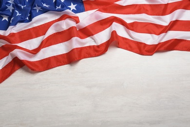 Photo of American flag on white wooden background, top view with space for text