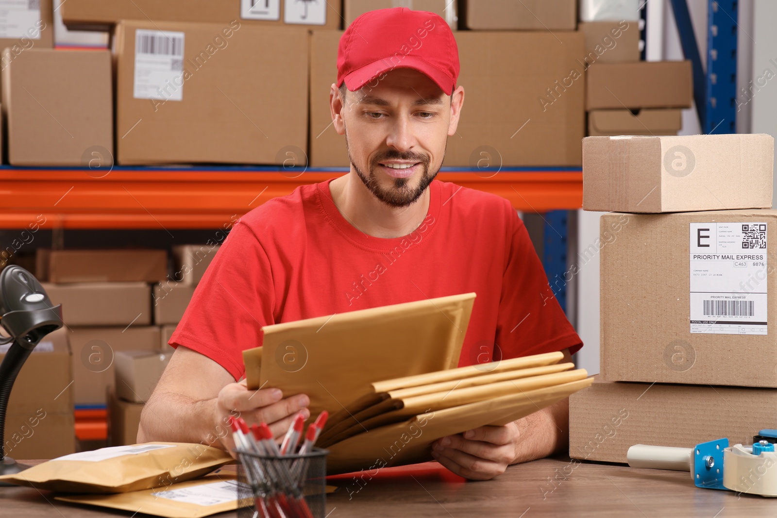 Photo of Post office worker with adhesive paper bags at counter indoors