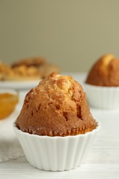 Photo of Delicious sweet muffin on white wooden table