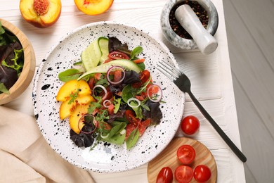 Photo of Delicious salad with vegetables and peach served on white wooden table, flat lay