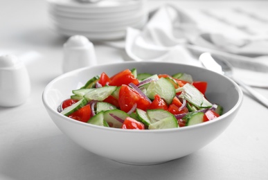 Photo of Delicious fresh cucumber tomato salad in bowl on table