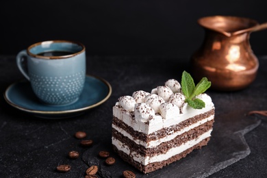 Photo of Composition with tiramisu cake on table against dark background