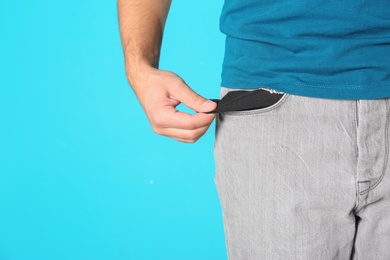 Photo of Man showing empty pocket on color background, closeup. Space for text