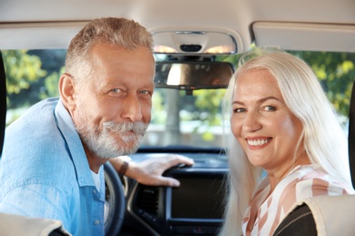 Photo of Happy senior couple sitting together in car