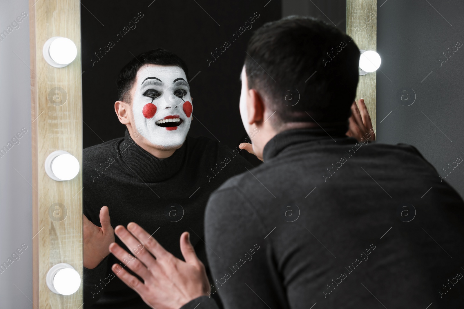 Photo of Mime artist posing near mirror in dressing room