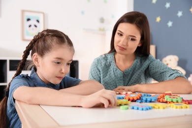 Young woman and little girl with autistic disorder playing at home