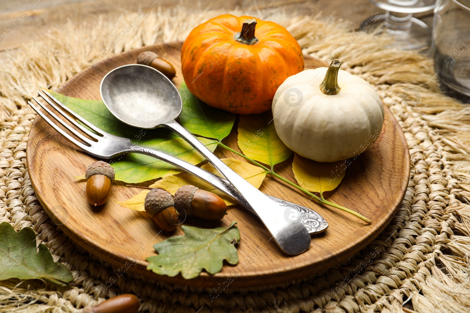 Photo of Seasonal place setting with pumpkins and other autumn decor on table