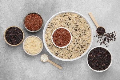 Different sorts of rice on grey table, flat lay
