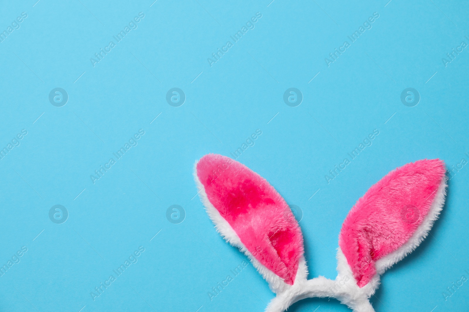 Photo of Funny headband with Easter bunny ears on color background, top view. Space for text