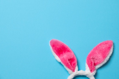 Funny headband with Easter bunny ears on color background, top view. Space for text