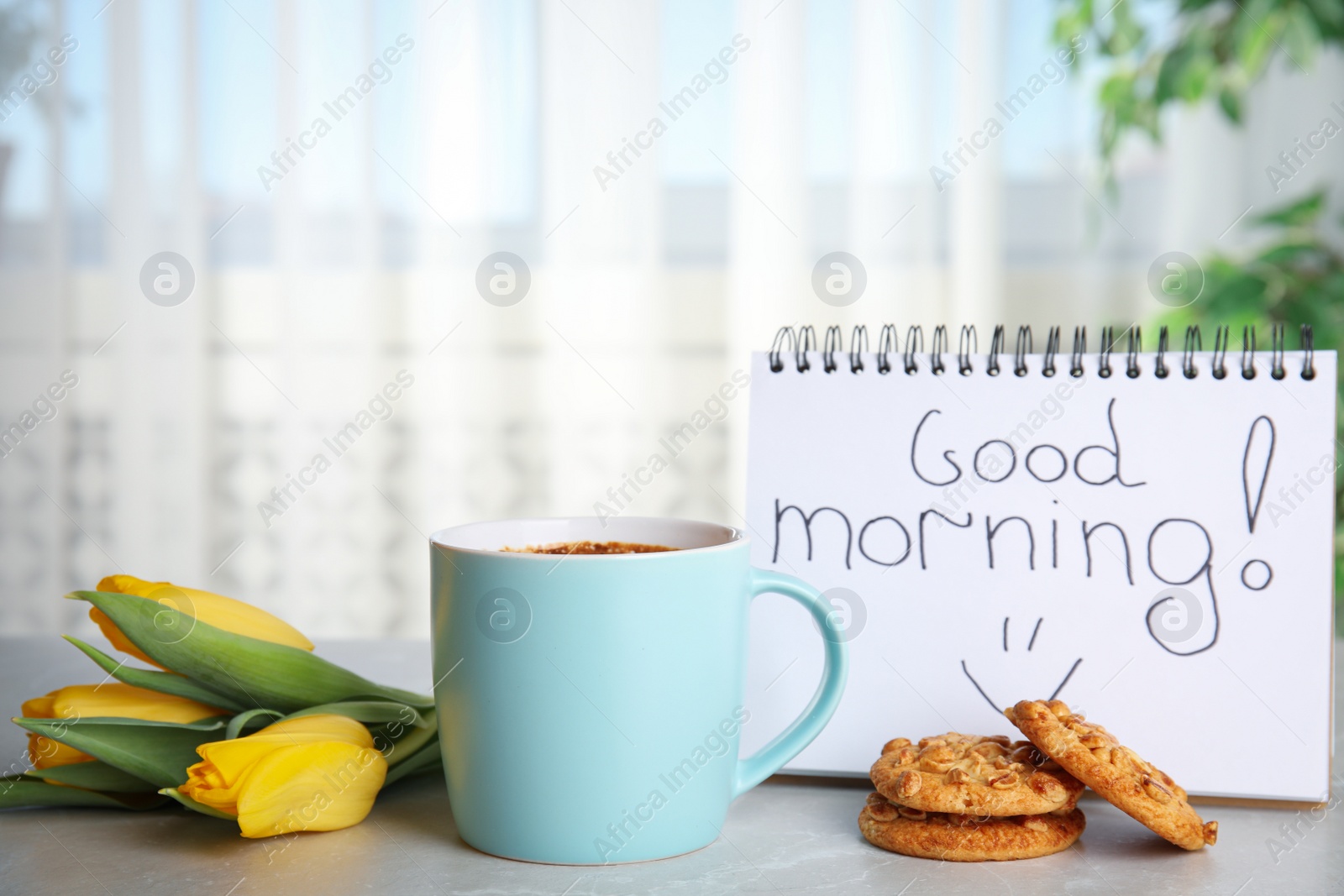 Photo of Delicious coffee, cookies, flowers and GOOD MORNING wish on grey table indoors