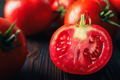 Photo of Fresh ripe tomatoes on wooden table, closeup