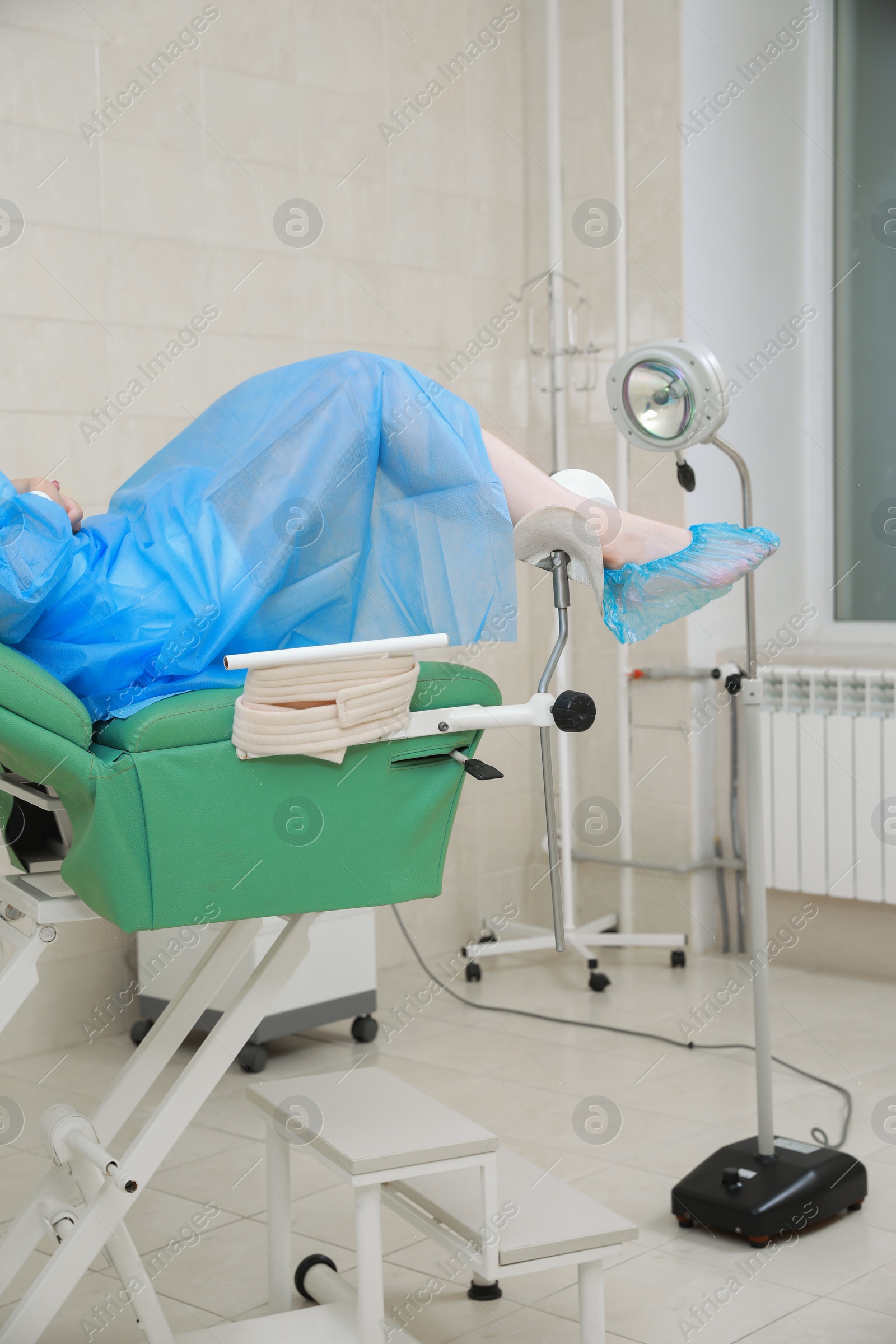 Photo of Gynecological checkup. Woman lying on examination chair in clinic, closeup