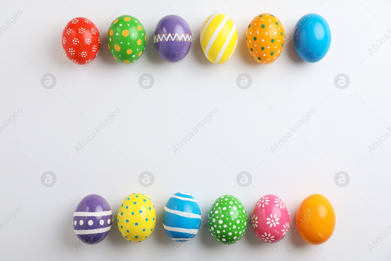 Photo of Decorated Easter eggs and space for text on white background, top view