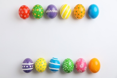 Decorated Easter eggs and space for text on white background, top view