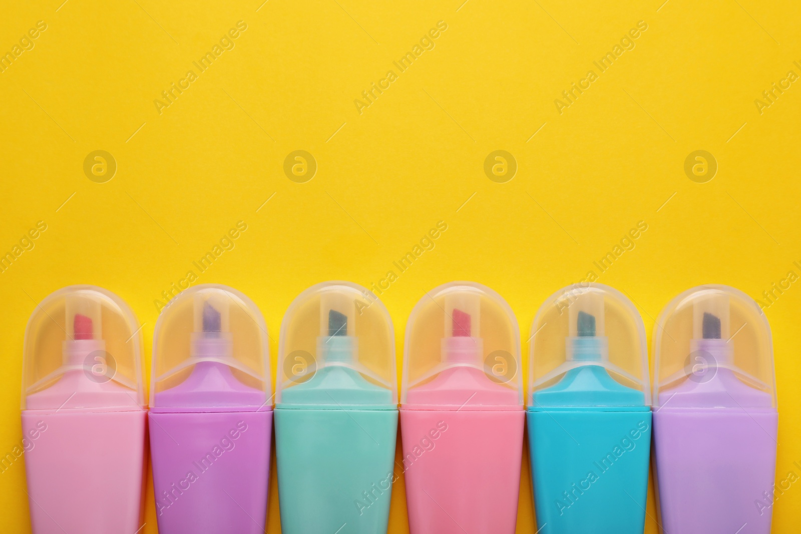 Photo of Many colorful markers on yellow background, flat lay. Space for text