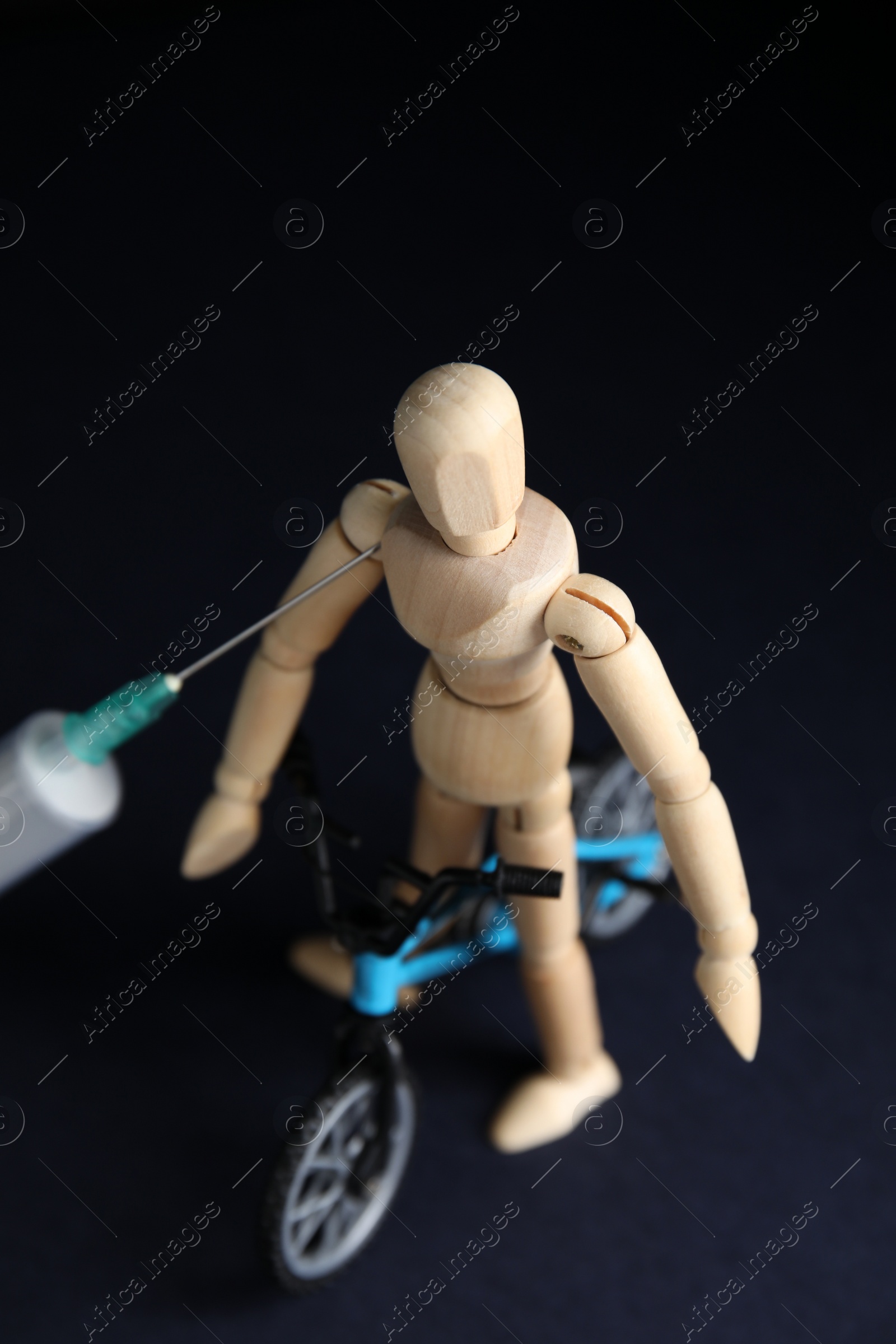 Photo of Syringe, sportsman and bike model on black background. Using doping in cycling sport concept
