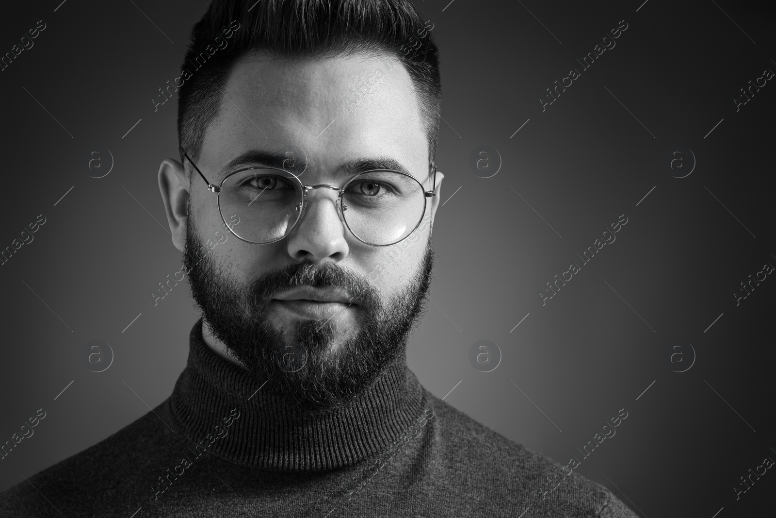 Photo of Portrait of handsome bearded man on dark background. Black and white effect