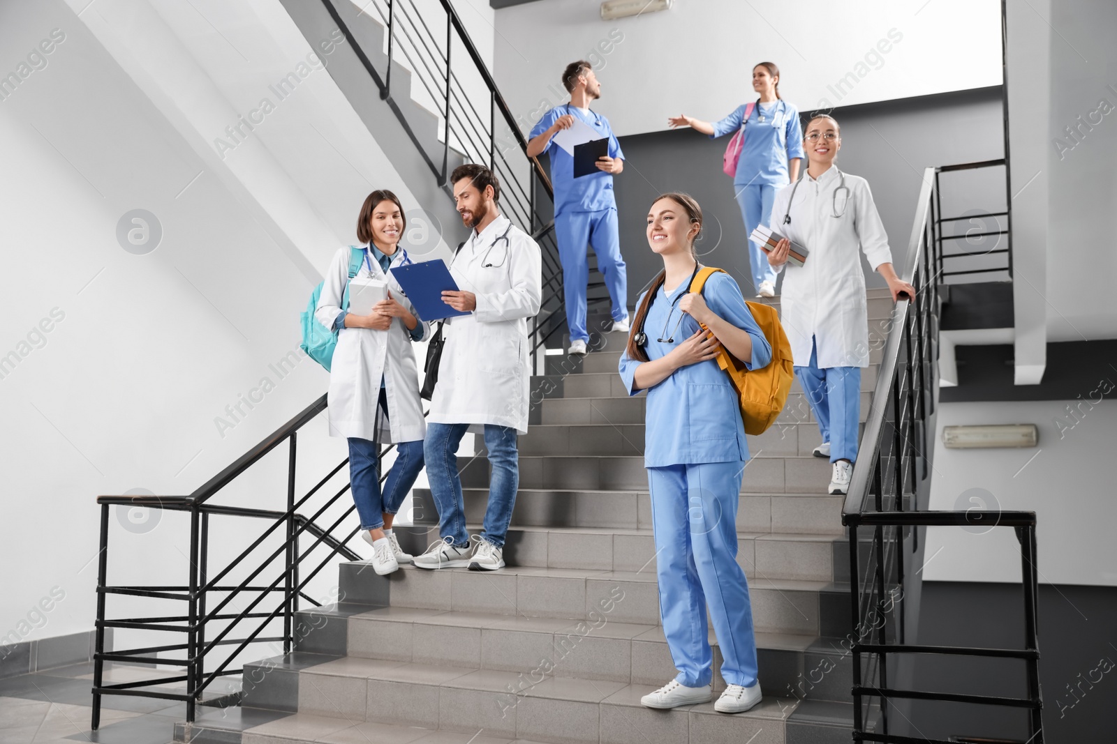 Photo of Medical students wearing uniforms on staircase in college