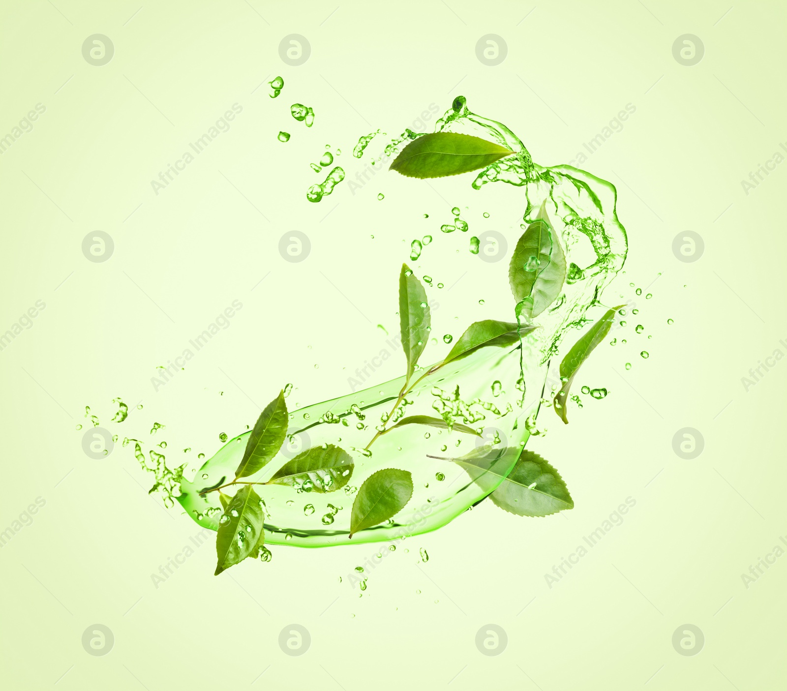 Image of Splashes of refreshing drink with leaves on pale green background. Green or matcha tea