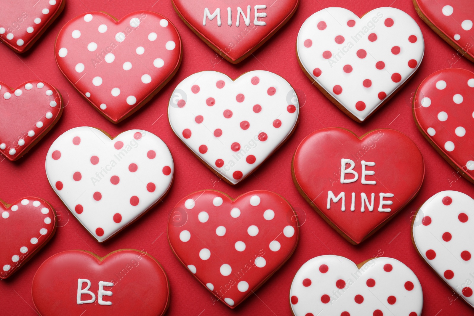 Photo of Decorated heart shaped cookies on red background, flat lay. Valentine's day treat