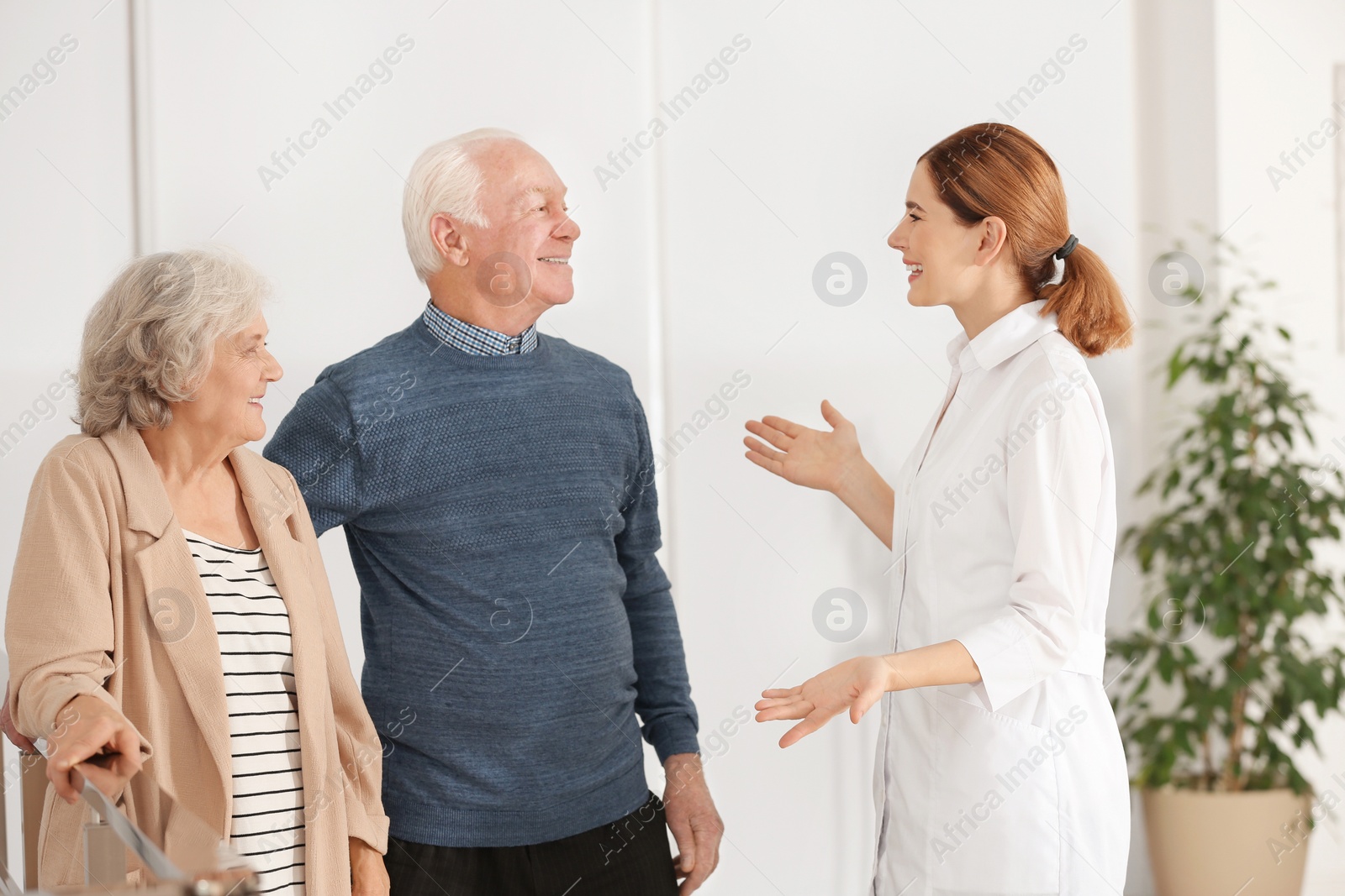 Photo of Elderly spouses with female caregiver in room