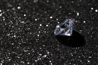 Beautiful dazzling diamond on dark shiny background. Space for text