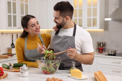 Photo of Lovely young couple cooking together in kitchen