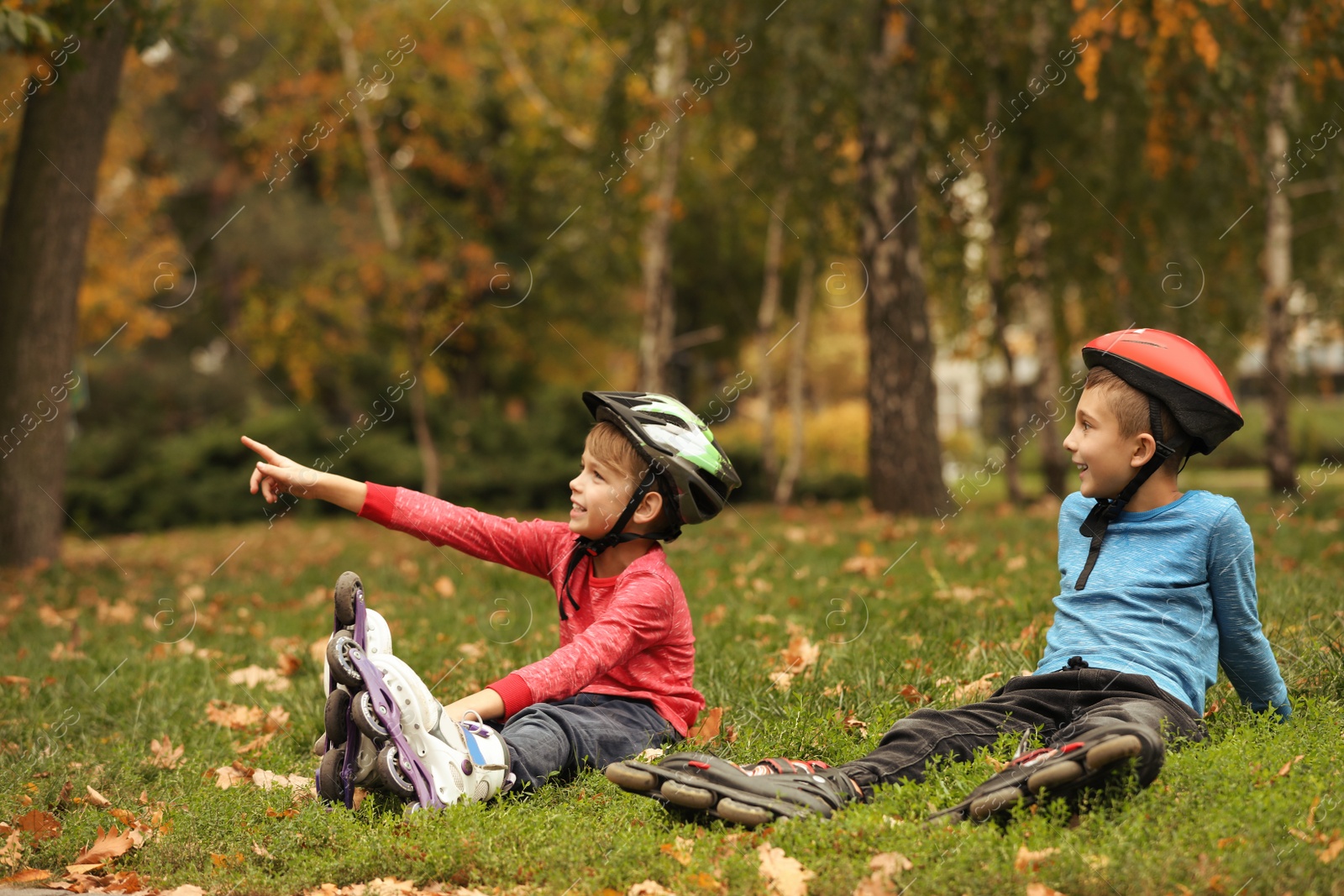 Photo of Cute roller skaters sitting on grass in park