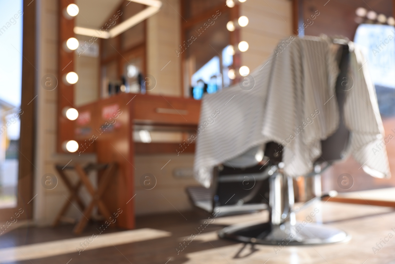 Photo of Blurred view of stylish barbershop interior with hairdresser workplace