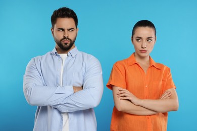 Photo of Resentful couple with crossed arms on light blue background