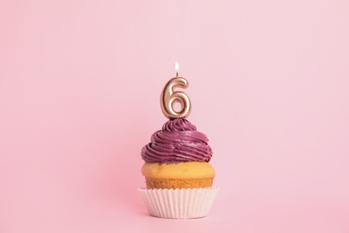 Photo of Birthday cupcake with number six candle on pink background