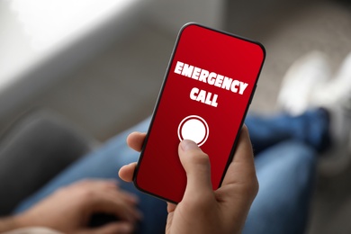 Image of Hotline service. Man making emergency call via smartphone indoors, closeup