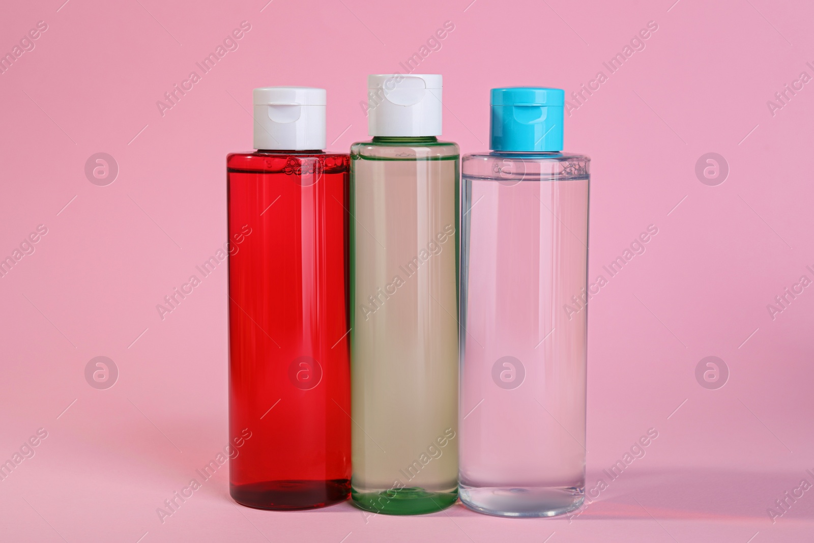 Photo of Bottles of micellar water on pink background
