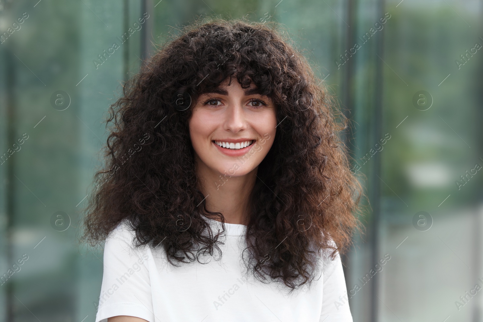 Photo of Portrait of beautiful woman posing on blurred background. Attractive lady smiling and looking into camera