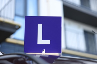 L-plate on car roof outdoors. Driving school