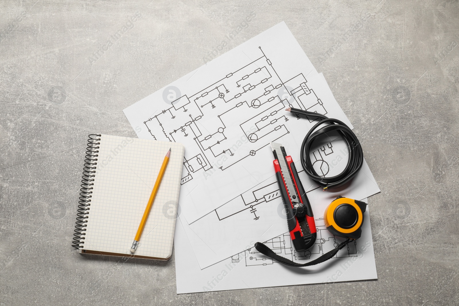 Photo of Wiring diagrams, wires and tools on grey table, flat lay