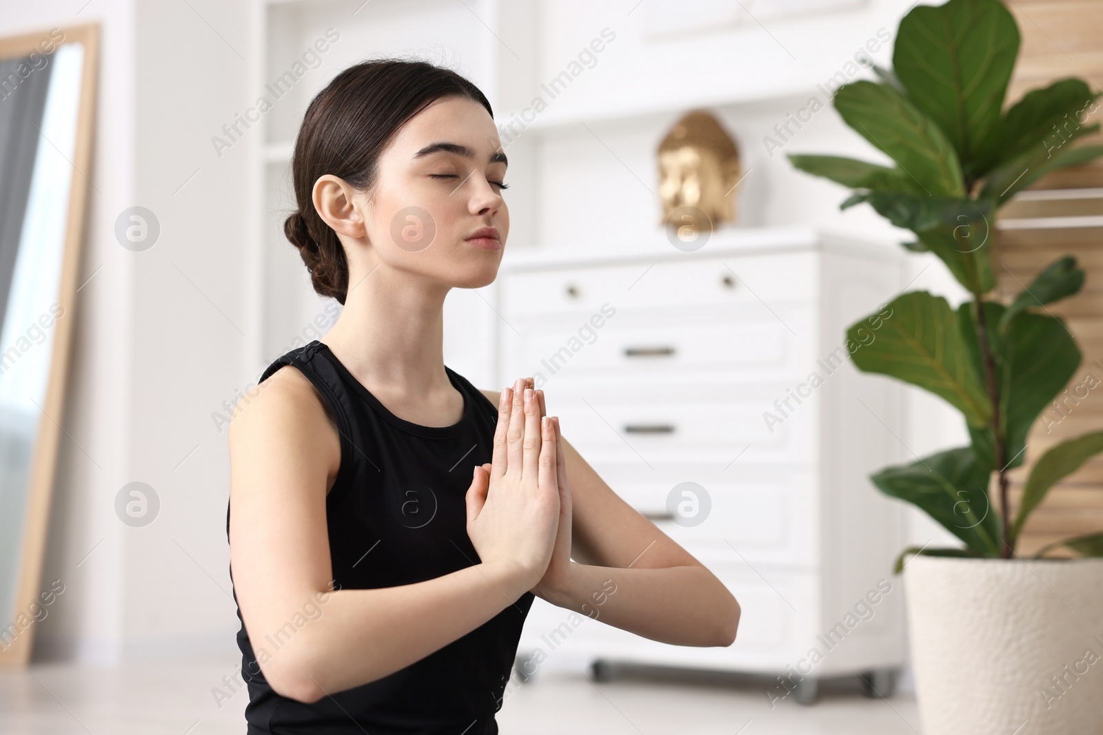 Photo of Beautiful girl meditating at home. Practicing yoga