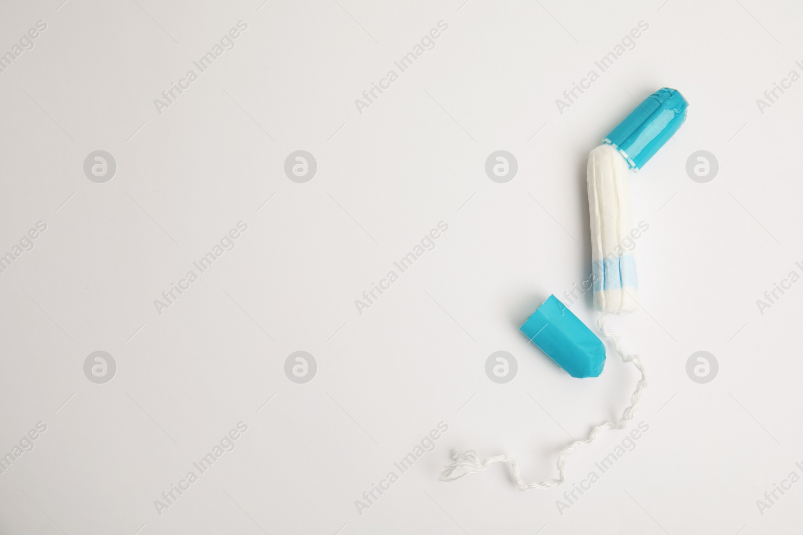 Photo of Tampon with package on light background, flat lay. Space for text