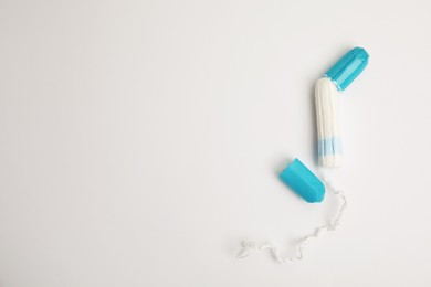Photo of Tampon with package on light background, flat lay. Space for text