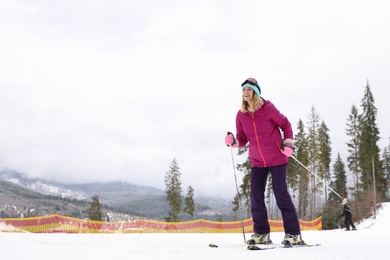 Photo of Female skier on slope at resort, space for text. Winter vacation
