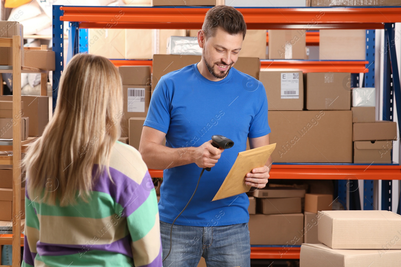 Photo of Woman and worker with scanner reading parcel barcode at post office