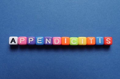 Photo of Word Appendicitis made of color cubes with letters on blue background, top view